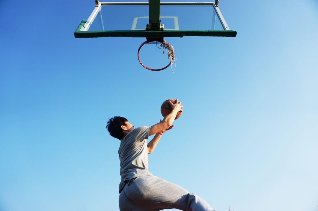 A man dunking a basketball representing the Big 12 Basketball Tournament and Kansas City car service.
